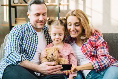 front-view-happy-family-looking-mobile-phone_23-2148045486